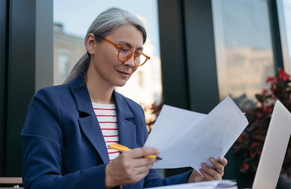 Lawyer reviewing documents while sitting outside their office.