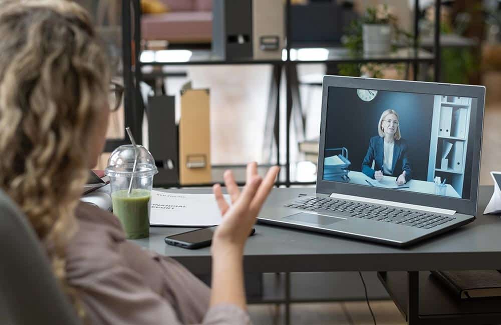 Lawyer talking to their client via video call in their office.